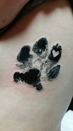 a woman with a tattoo on her stomach that has black ink in the shape of a dog's paw