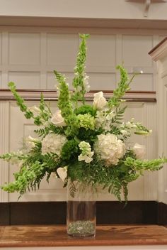 a vase filled with white and green flowers