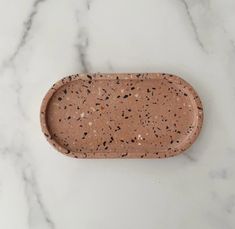 a marble tray with black speckles on it sitting on a white countertop