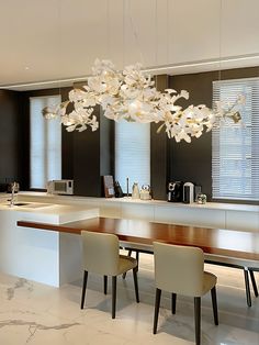 a dining room table with four chairs and a chandelier hanging from the ceiling