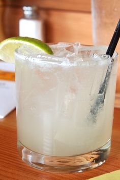 there is a glass with ice and a lime on the table