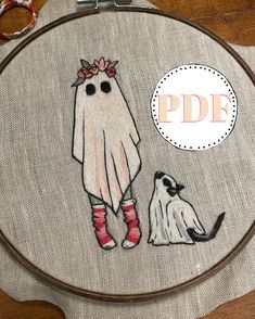 a cross stitch pattern with a white ghost and a black cat