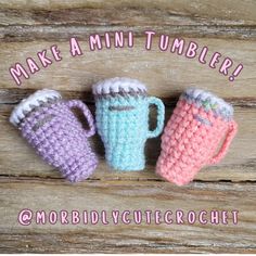 three crocheted coffee mugs sitting next to each other on top of a wooden table