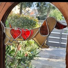 a stained glass window with hearts in the shape of a bird on it's wings