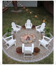 a fire pit surrounded by white chairs and potted plants with lights in the background