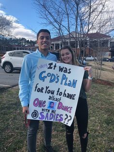 a man and woman holding up a sign