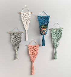 four macrame wall hangings with plants in them