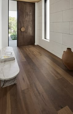 a white marble bench sitting in the middle of a room with wooden floors and walls