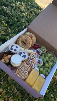 a box filled with lots of different types of cheeses and crackers on top of grass