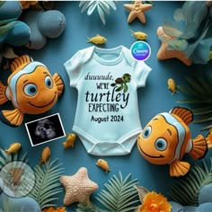 a baby's bodysuit with an image of two fish on it, surrounded by sea life