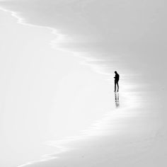 a person standing in the middle of an empty beach