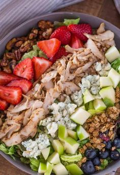 a close up of a bowl of food with strawberries and blueberries on the side