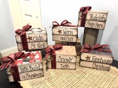 six wooden blocks with christmas sayings and bows on them sitting on a table in front of a door