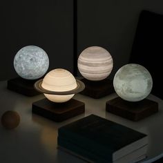 three different types of lights sitting on top of a table next to a book and an egg