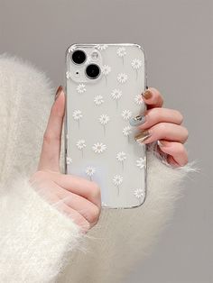 a woman holding up her phone case with daisies on it