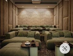 a living room filled with green couches and coffee tables in front of a wall