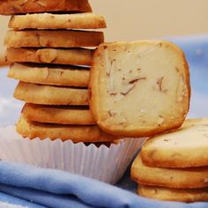 a stack of cookies sitting on top of a blue cloth next to a cupcake