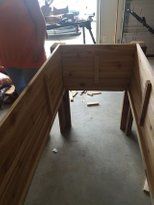 a person standing in front of a wooden bench made out of plywood planks