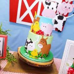 there is a three tier cake with farm animals on it and other decorations in the background