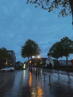 a city street at night with cars parked on the side