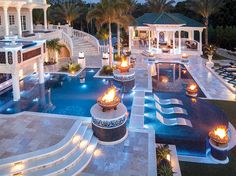 an aerial view of a mansion with pool and fire pit