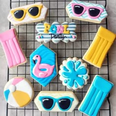 some decorated cookies on a cooling rack with sunglasses and other items in the shape of sun glasses