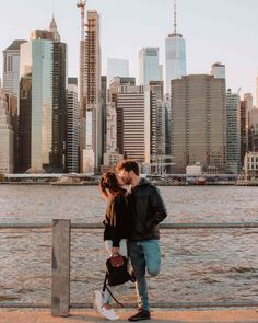 a man and woman standing next to each other near the water