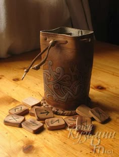 a wooden bucket sitting on top of a wooden table next to some wood letter tiles