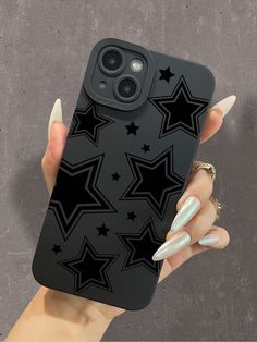 a woman's hand holding an iphone case with black stars and nails on it