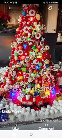 a christmas tree made out of candy canes and candies is shown on the phone