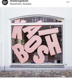 a pink sign that says boosh in front of a window