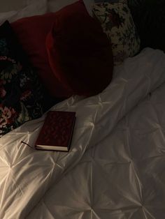 a book is laying on the bed with pillows