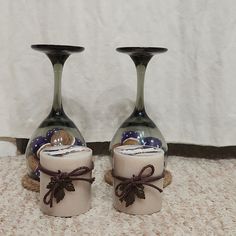 two vases with candles in them sitting on the floor next to each other,