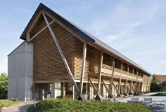 a large building with wooden slats on the front and sides, next to a swimming pool