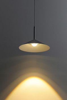 a light that is hanging from a ceiling in a room with white walls and flooring