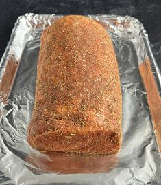 a loaf of bread sitting on top of aluminum foil covered in seasoning sprinkles