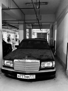 a black and white photo of a car parked in a garage