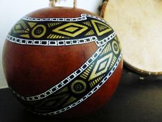 an artisticly decorated apple sitting on top of a table next to two drum heads