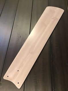 a white surfboard laying on top of a wooden floor next to a bottle opener