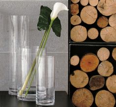 a white flower sitting in a vase on top of a table next to some glasses