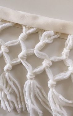 a close up of a white piece of cloth with tassels on the edge