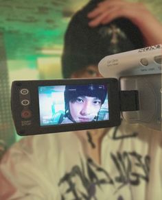 a person holding up a video camera to take a picture