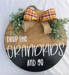 a wooden sign that says drop the oranges and go with two bows on it