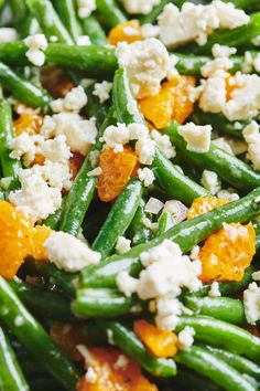 green beans, oranges and feta cheese are mixed together to make a salad