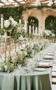 a long table with candles and flowers on it is set up for a formal function