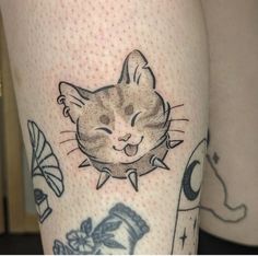 a close up of a person's leg with tattoos on it and a cat