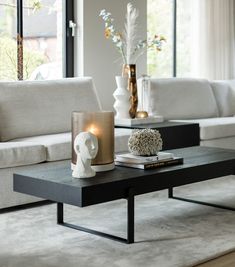 a living room with white couches and a coffee table in front of a large window