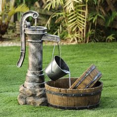 an old fashioned water faucet and bucket in the grass