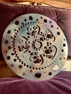 a metal plate sitting on top of a purple couch