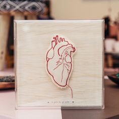 a wooden plaque with a drawing of a human heart on it